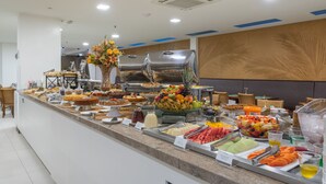 A buffet with various food items and a decorative centerpiece. - Palms Ponta Verde by Tropicalis (Maceió)