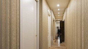 A narrow hallway with wooden flooring and striped wallpaper on the walls. - Relais Bocca di Leone (Rome)