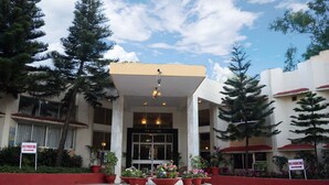 A hotel entrance with a 'NO PARKING' sign, a covered entrance, and potted plants in front. - Hotel Sunset Inn Mount Abu with Swimming Pool (Abu Road)