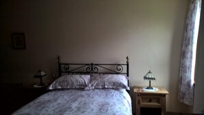 A bedroom with a bed, two bedside tables, and a nightstand. - Balloan House (Muir of Ord)