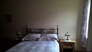 A bedroom with a bed, two bedside tables, and a nightstand. - Balloan House (Muir of Ord)
