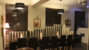 A restaurant with striped booths, pendant lighting, and a candle on the table. - The Bell Guest House (Peterlee)