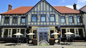 A traditional building with a sign reading "The Bell Guesthouse" and a courtyard area with outdoor seating. - The Bell Guest House (Peterlee)