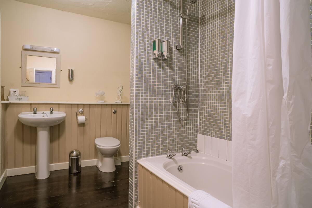 A bathroom with a sink, toilet, and bathtub.