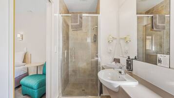A modern bathroom with a glass-enclosed shower, a sink, and a mirror.
