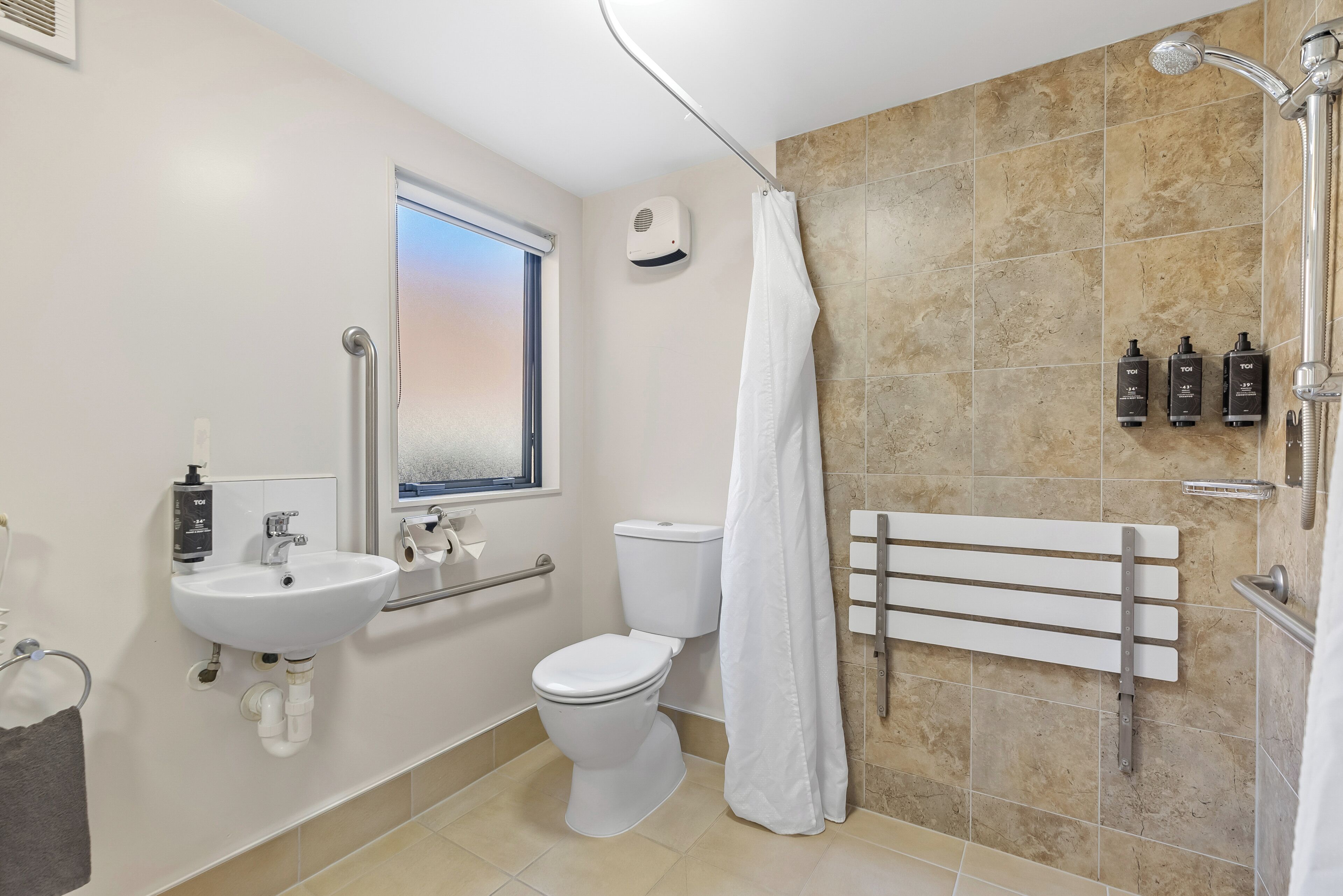 A modern bathroom with a white sink, toilet, and shower.