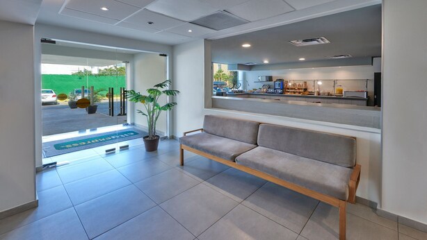 Una hall moderna con una panca, una reception e vista sul parcheggio.