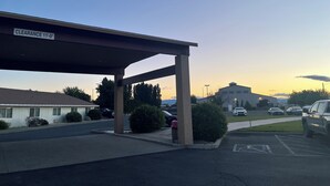 Un parking doté d’une zone abritée signalée par la mention « hauteur libre : 3,35 mètres », avec un bâtiment en arrière-plan.