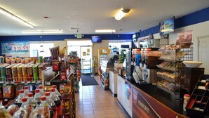 L'intérieur d'une épicerie, avec des étagères remplies de collations, de boissons et de produits frais.