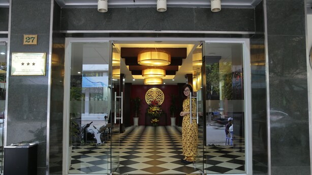A hotel entrance with a checkered floor, a large circular decorative piece, and a number sign indicating the location. - Holidays-hanoi Hotel (Hanoi)