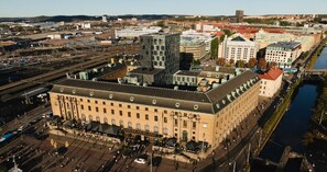 Suuri, historiallinen rakennus, jonka keskellä on sisäpiha, ja jonka ympärillä on moderneja rakennuksia.