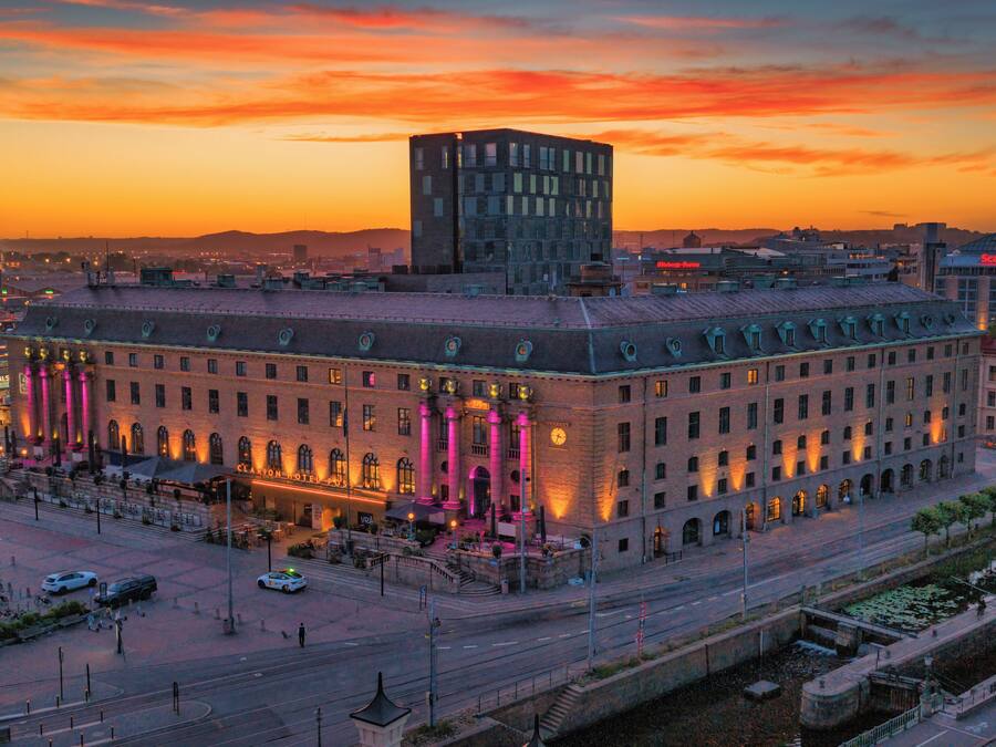 A historic building with a central courtyard, a clock tower, and a modern glass structure on top.