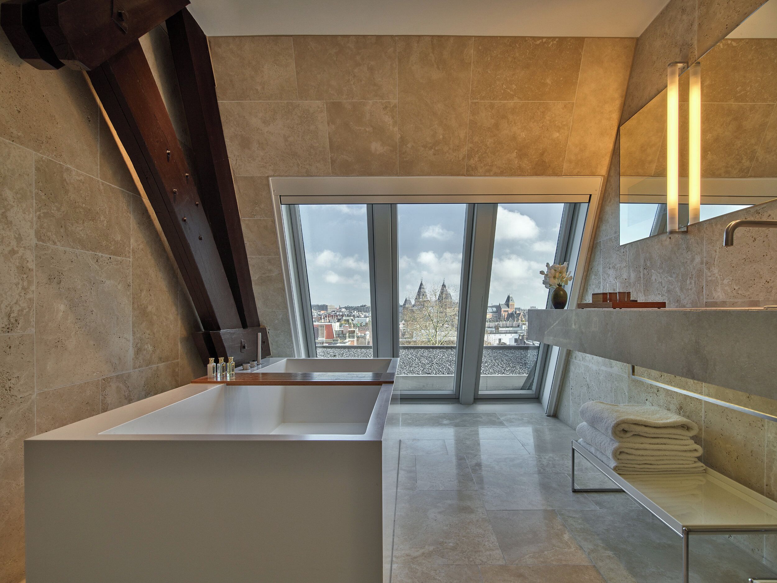 Un baño moderno con un tragaluz grande, una bañera y un lavamanos.