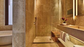 Une salle de bain moderne dotée d’une douche à l’italienne, d’une baignoire et d’un meuble-lavabo avec un miroir.
