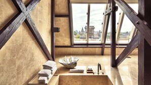 A modern bathroom with a large bathtub, a bowl sink, and a window offering a city view. - Mandarin Oriental Conservatorium, Amsterdam (Amsterdam)