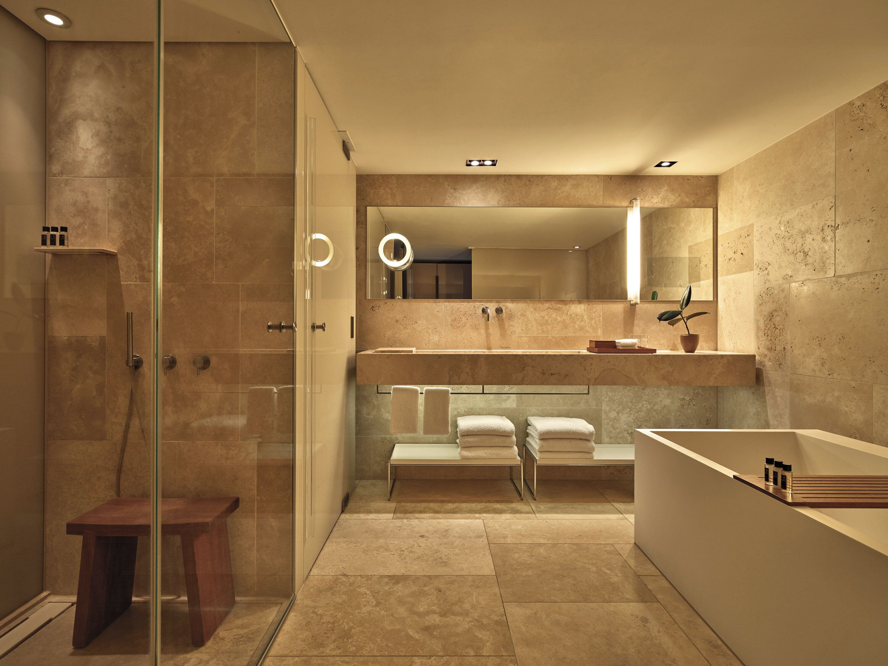Une salle de bain moderne avec une douche à parois de verre, un meuble-lavabo avec un miroir et une baignoire.