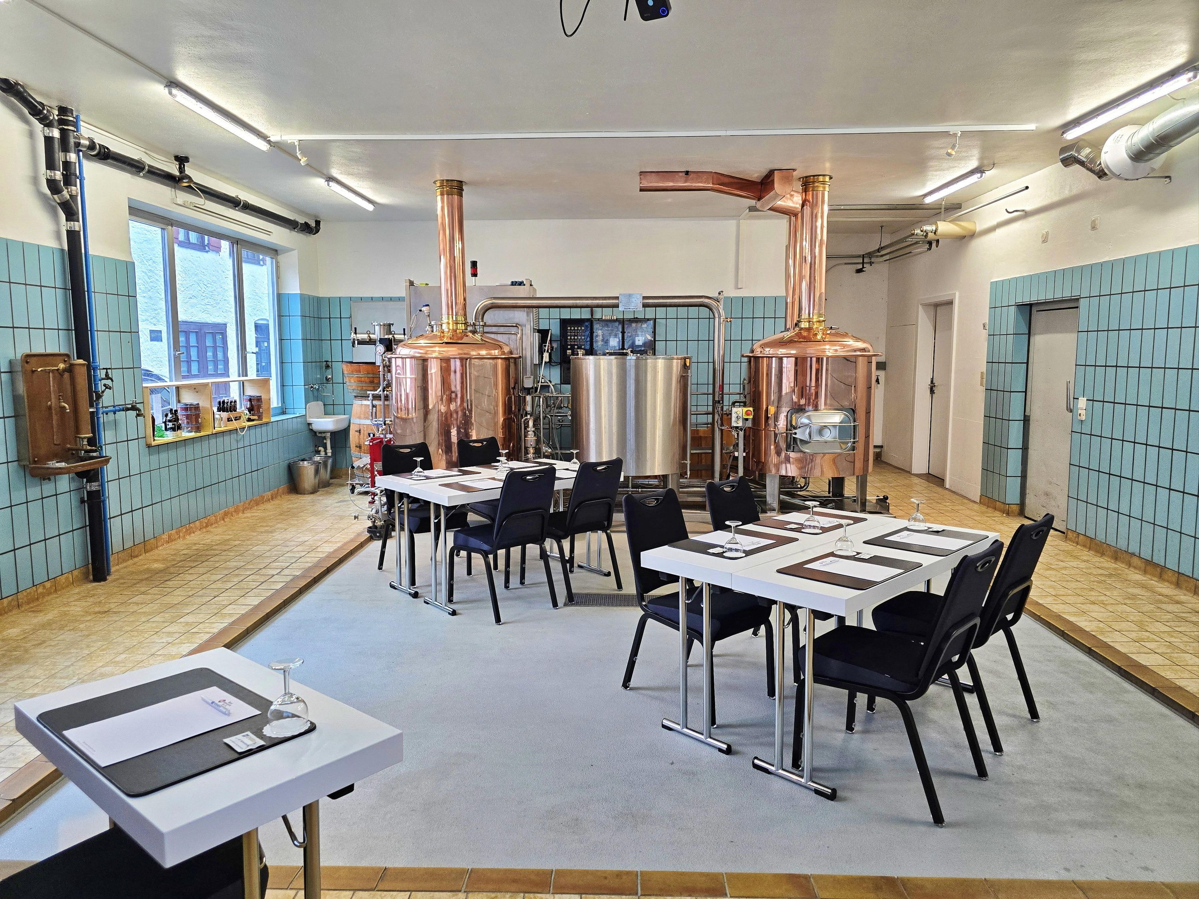 A modern conference room with tables, chairs, and industrial equipment.