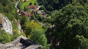 A mountain landscape with a village, a road, and a bicycle helmet on a rock.