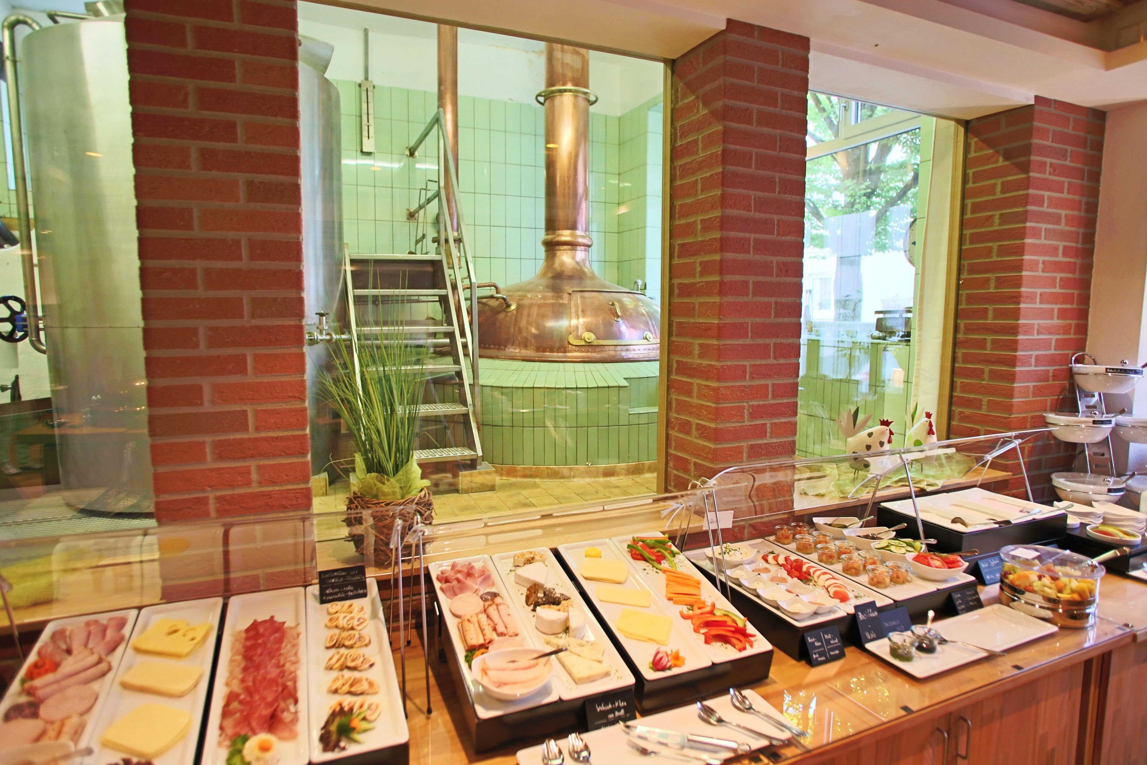 Un buffet con diversi piatti e una grande pentola di rame sullo sfondo.