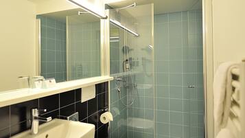 A modern bathroom with a sink, toilet, and glass-enclosed shower.