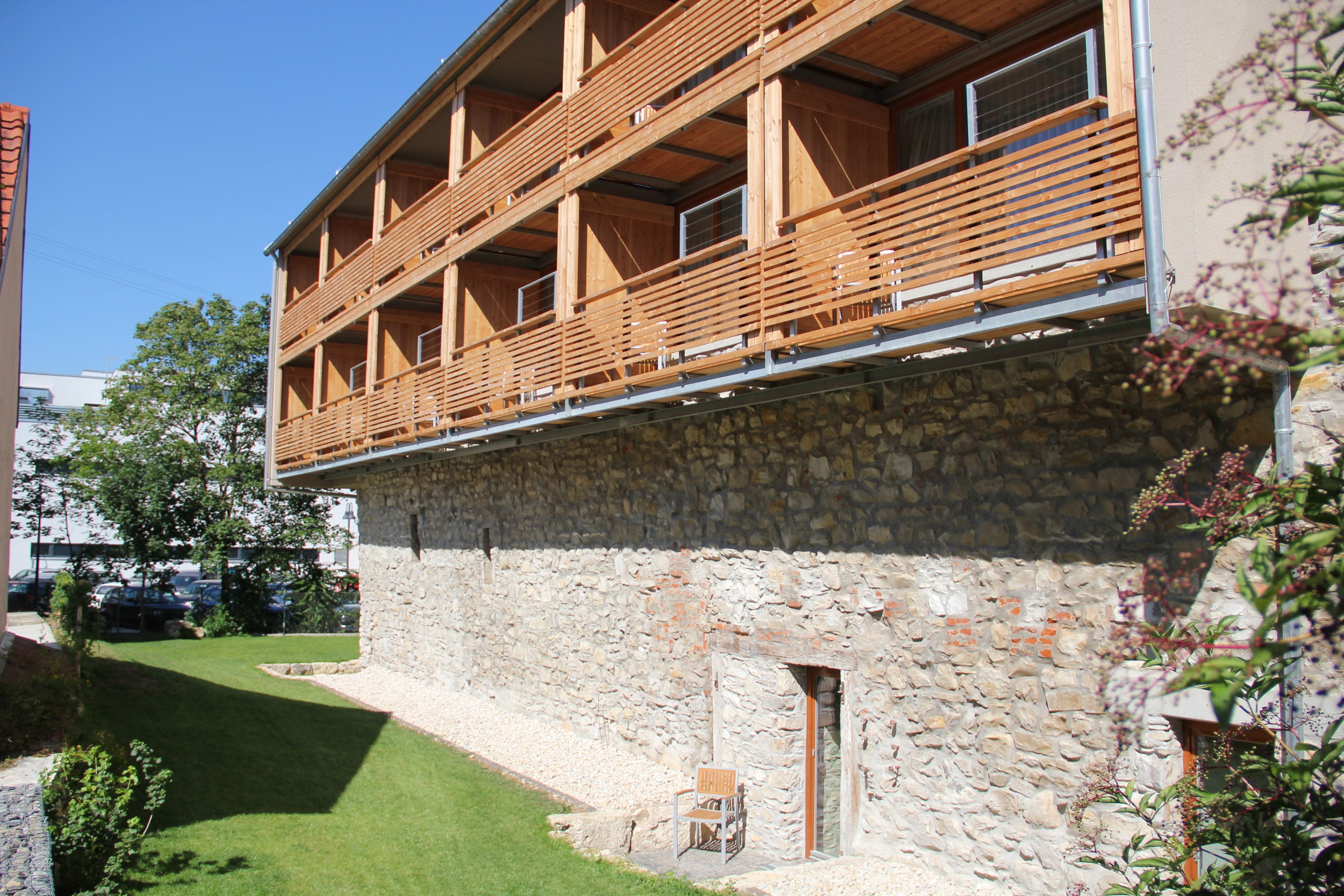 Un edificio de dos pisos con fachada de piedra y balcones de madera.