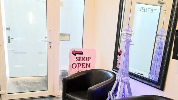 A reception area with a 'Shop Open' sign, a 'Welcome' sign, and a decorative Eiffel Tower model. - Waters Edge (Blackpool)