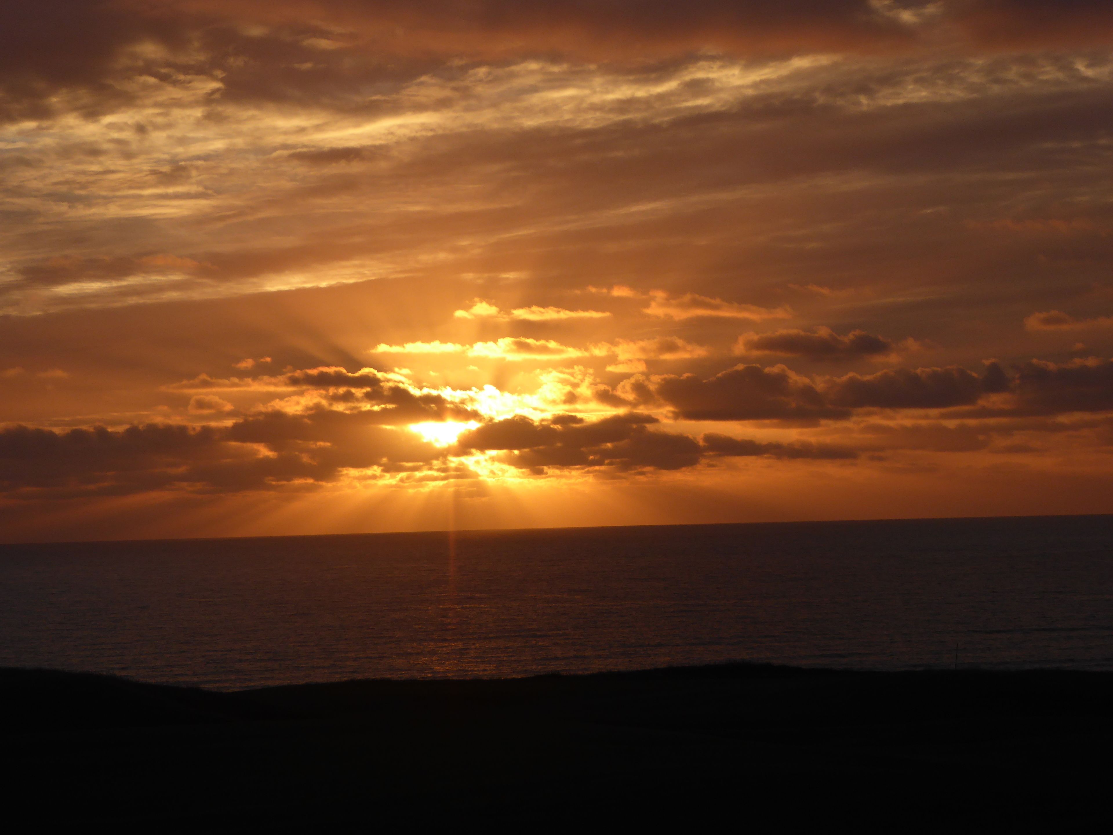 Atardecer sobre el océano con nubes.