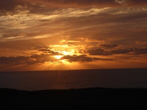 A sunset over the ocean with clouds.