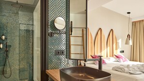 Un bany modern amb un envàs de vidre per a la dutxa, un lavabo gran i un armari de tocador de fusta.