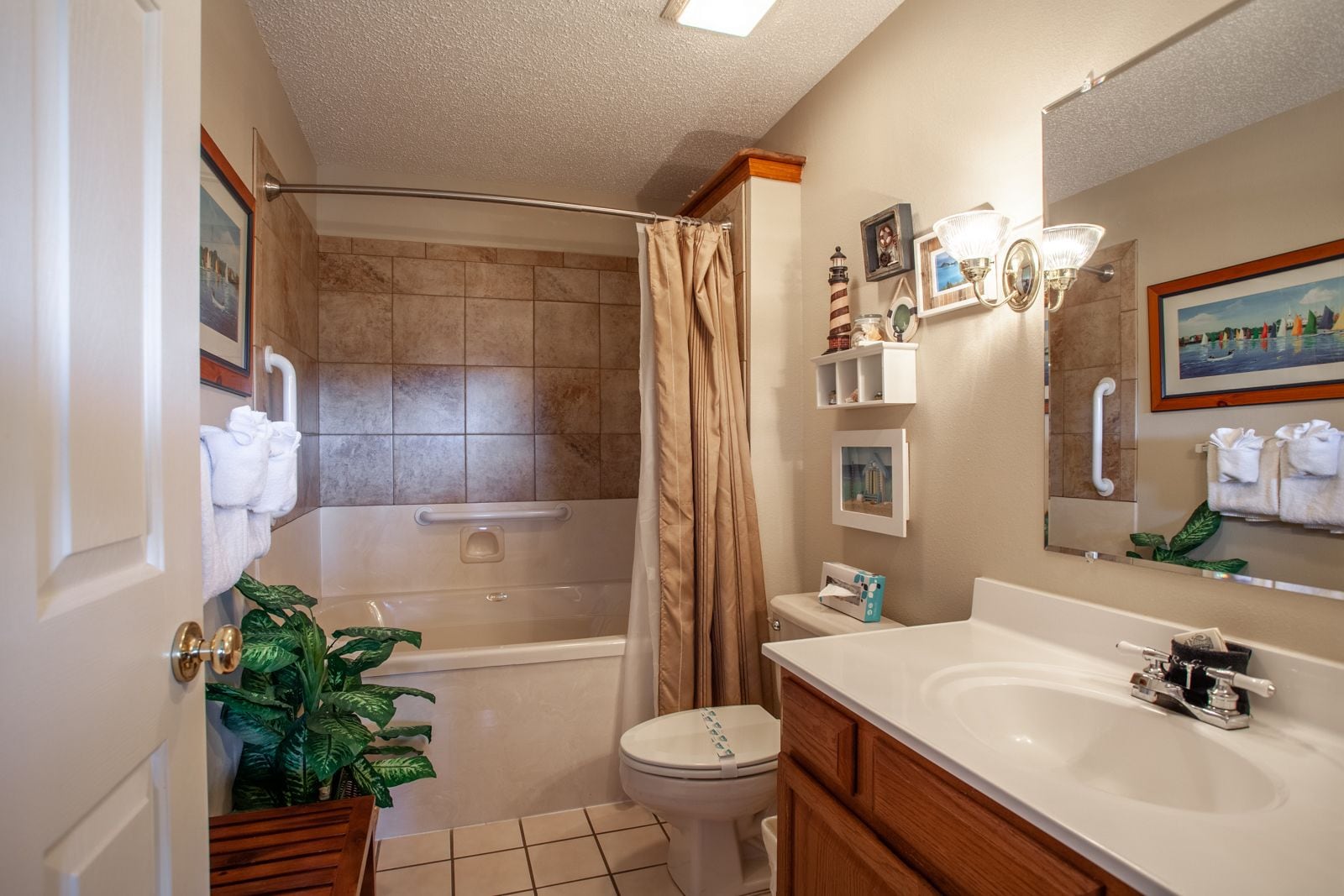 A bathroom with a bathtub, toilet, sink, and shower curtain.