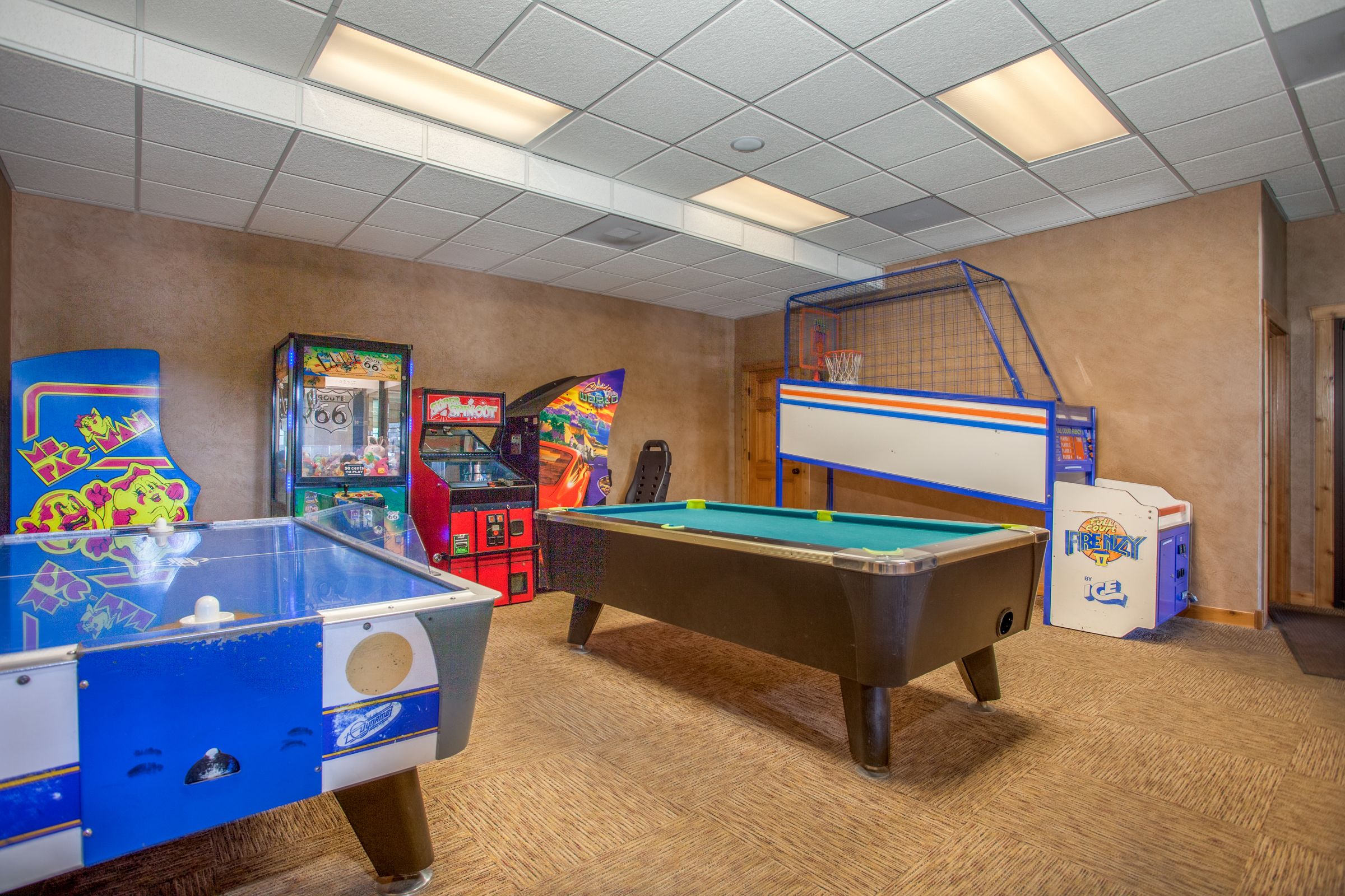 Een recreatieruimte met een pooltafel, tafelvoetbal en verschillende spelautomaten.