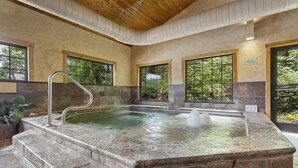 A hot tub area with stone steps and a wooden ceiling. - The Village At Indian Point Resort (Branson)
