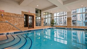 An indoor swimming pool with clear water, a tiled floor, and a metal handrail. - Best Western Plus Chateau Inn Sylvan Lake (Sylvan Lake)