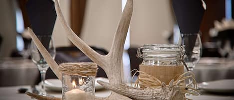 Una mesa decorada con adornos de asta, una vela y un tarro de cristal.