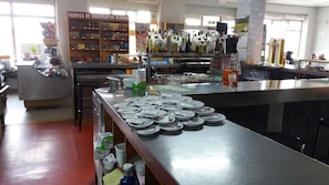 A restaurant with a chocolate display, a bar area, and a counter with plates and cutlery. - Hostal Restaurante Delfin (Astorga)