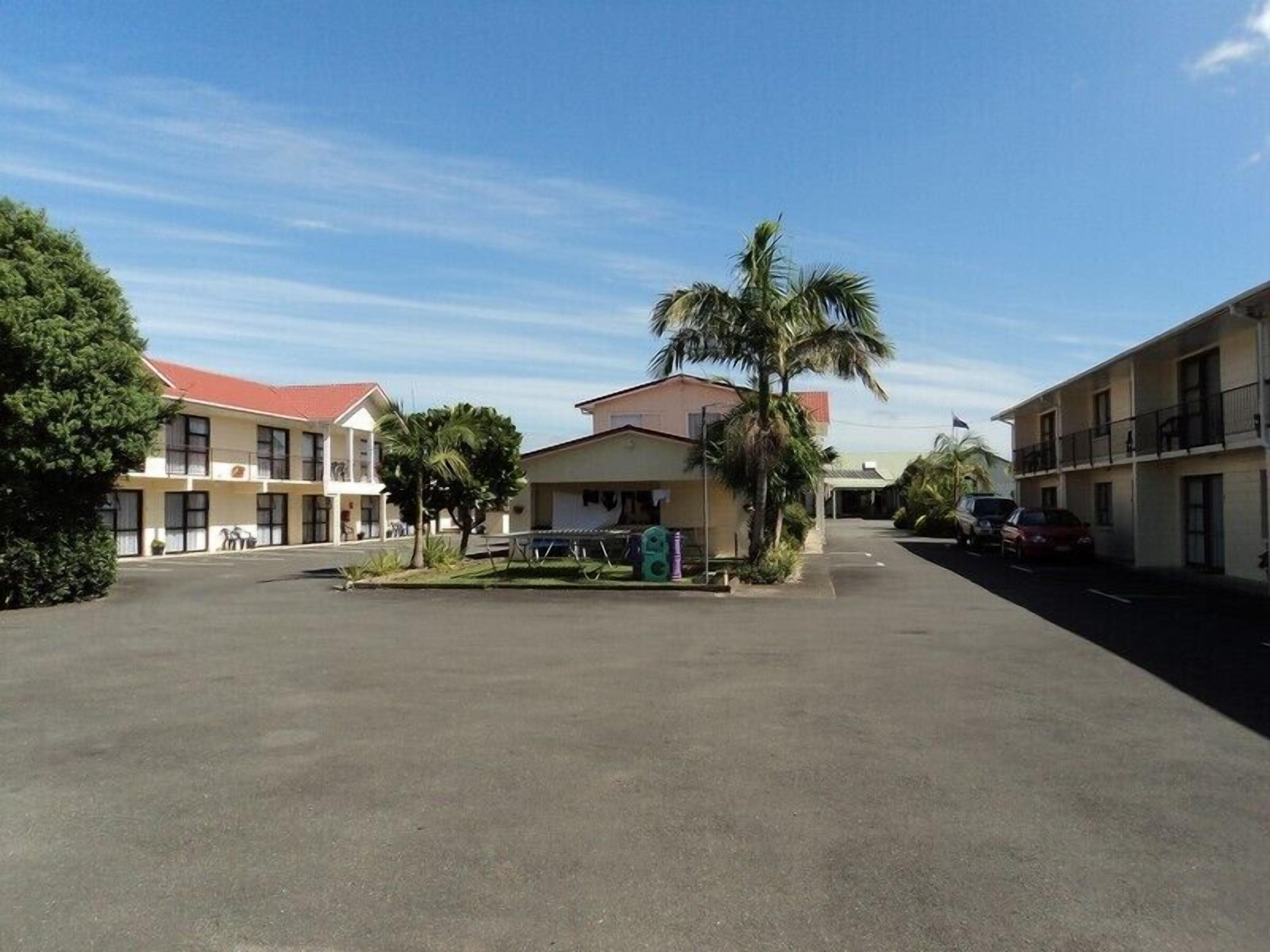 A hotel with a central courtyard, multiple buildings, and a clear sky.