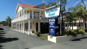 A two-story motel with a balcony, a swimming pool, and a sign advertising hot spa entry.