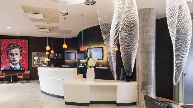 A modern reception area with a curved desk, multiple monitors, and pendant lighting. - Hôtel Mercure Lyon Centre - Gare Part Dieu (Lyon)
