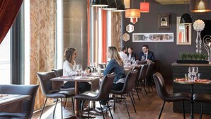 A restaurant with a modern interior, featuring leather chairs, a variety of pendant lights, and a large window with patterned curtains. - Hôtel Mercure Lyon Centre - Gare Part Dieu (Lyon)