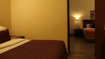 A hotel room with a bed, a nightstand, and a wall-mounted lamp.