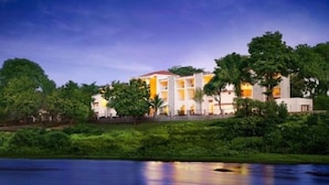 A multi-story hotel with a pool in the foreground. - Gir Serai - IHCL SeleQtions (Mendarda)