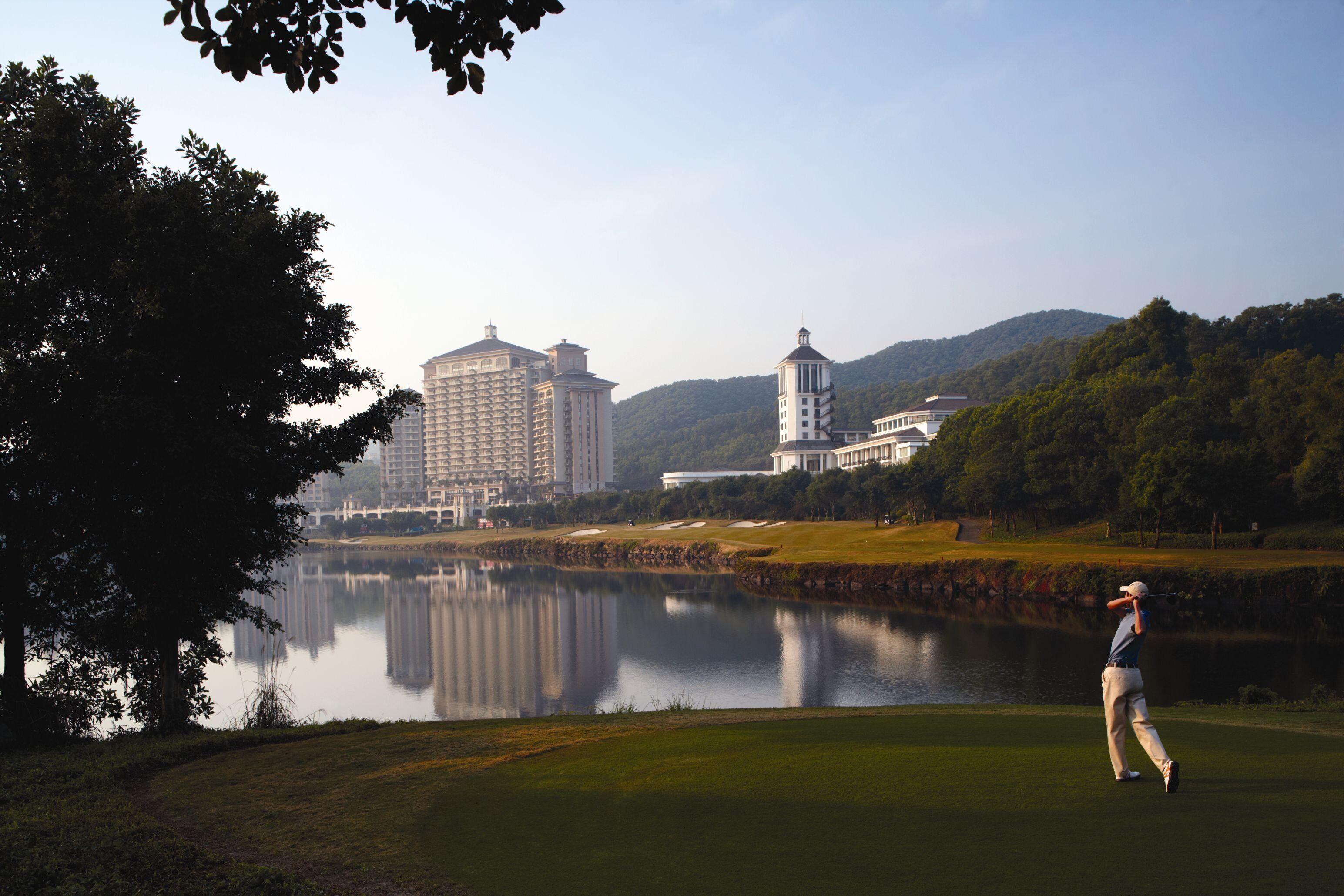 A golf course with a large building in the background.