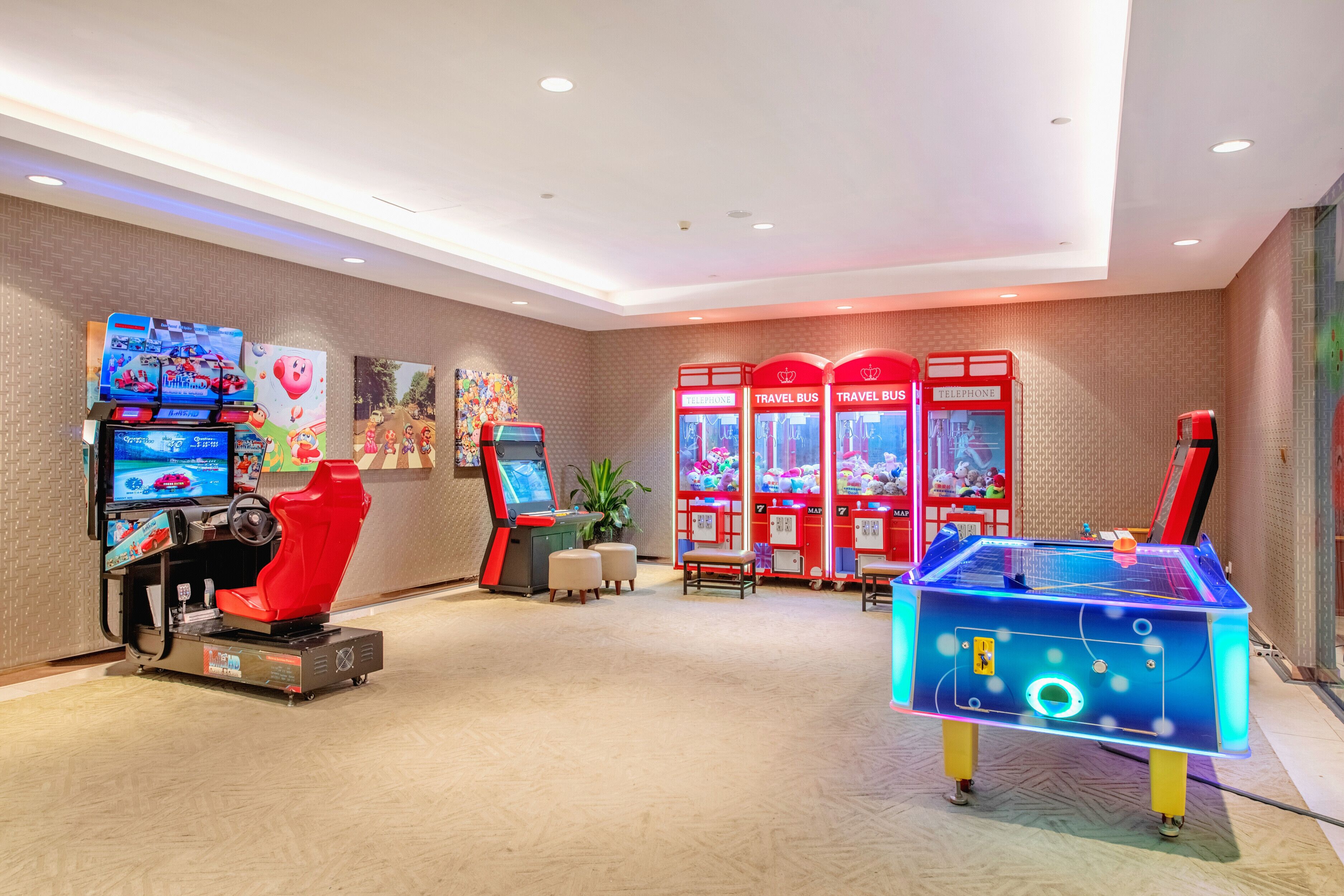 A gaming area with arcade machines, a racing simulator, and claw machines.