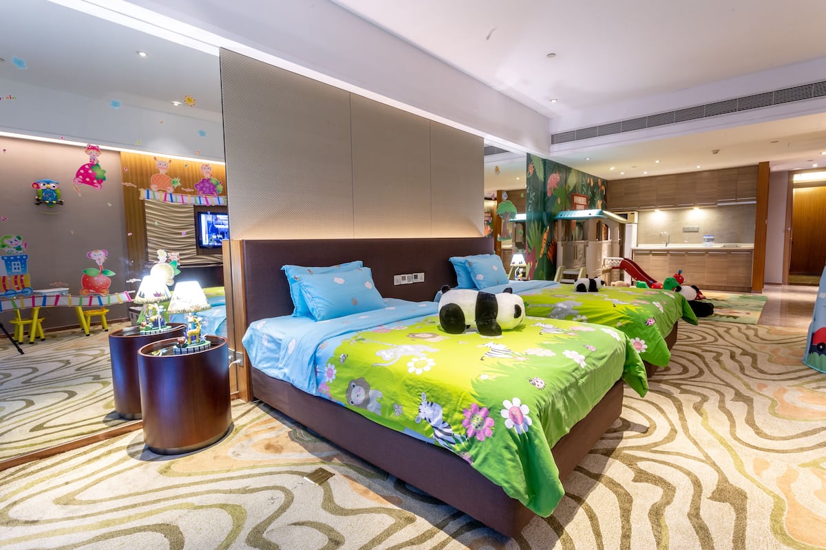 Una habitación de hotel con una cama grande, un escritorio y un kitchenette.