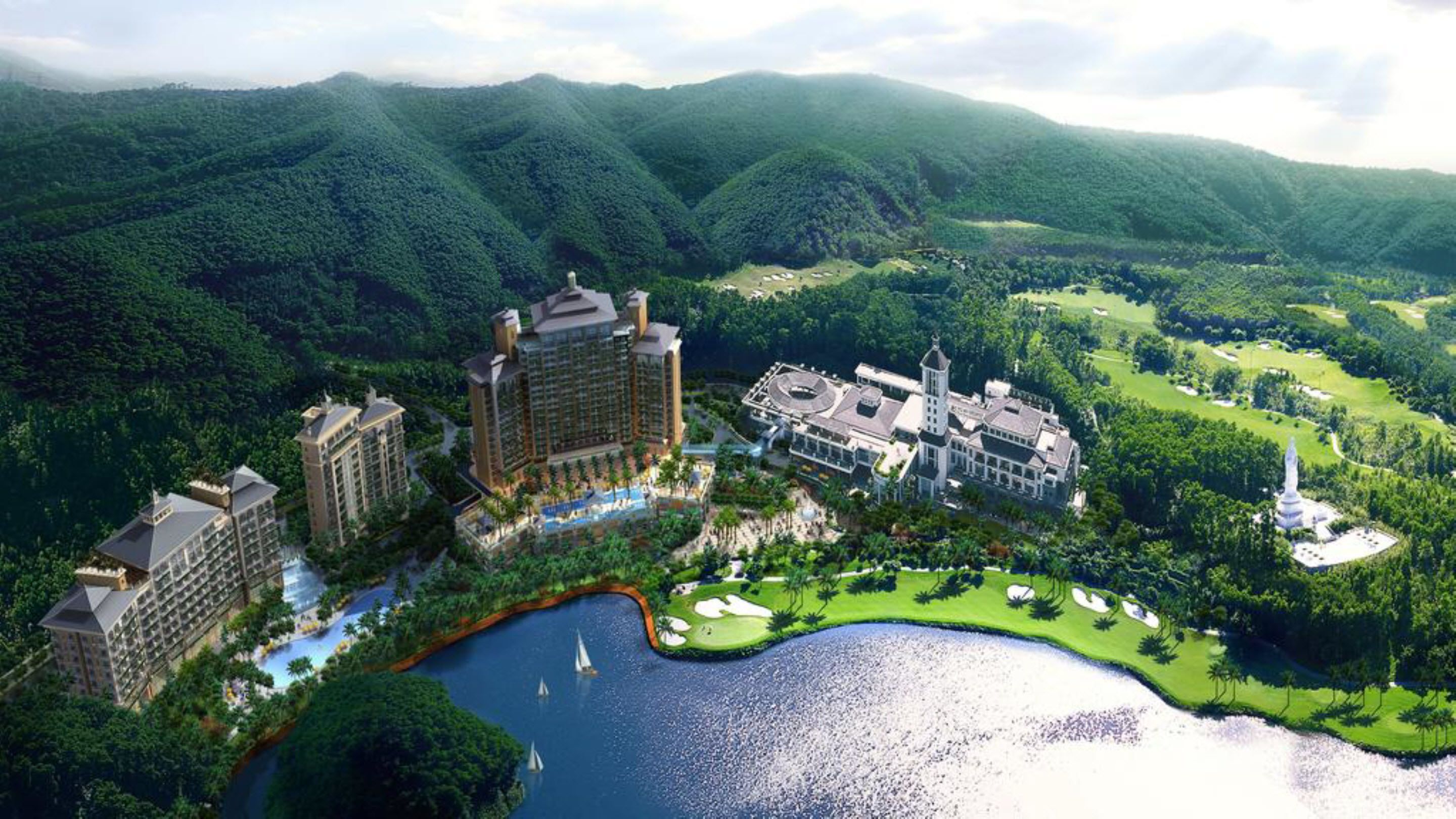 A resort with multiple buildings, a golf course, and a body of water.