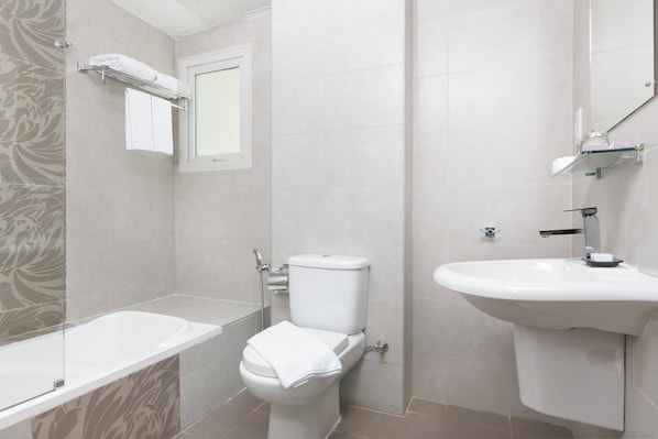 A modern bathroom with a bathtub, toilet, and sink.