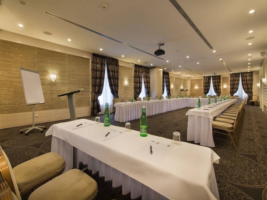 A conference room with long tables, chairs, and a whiteboard.
