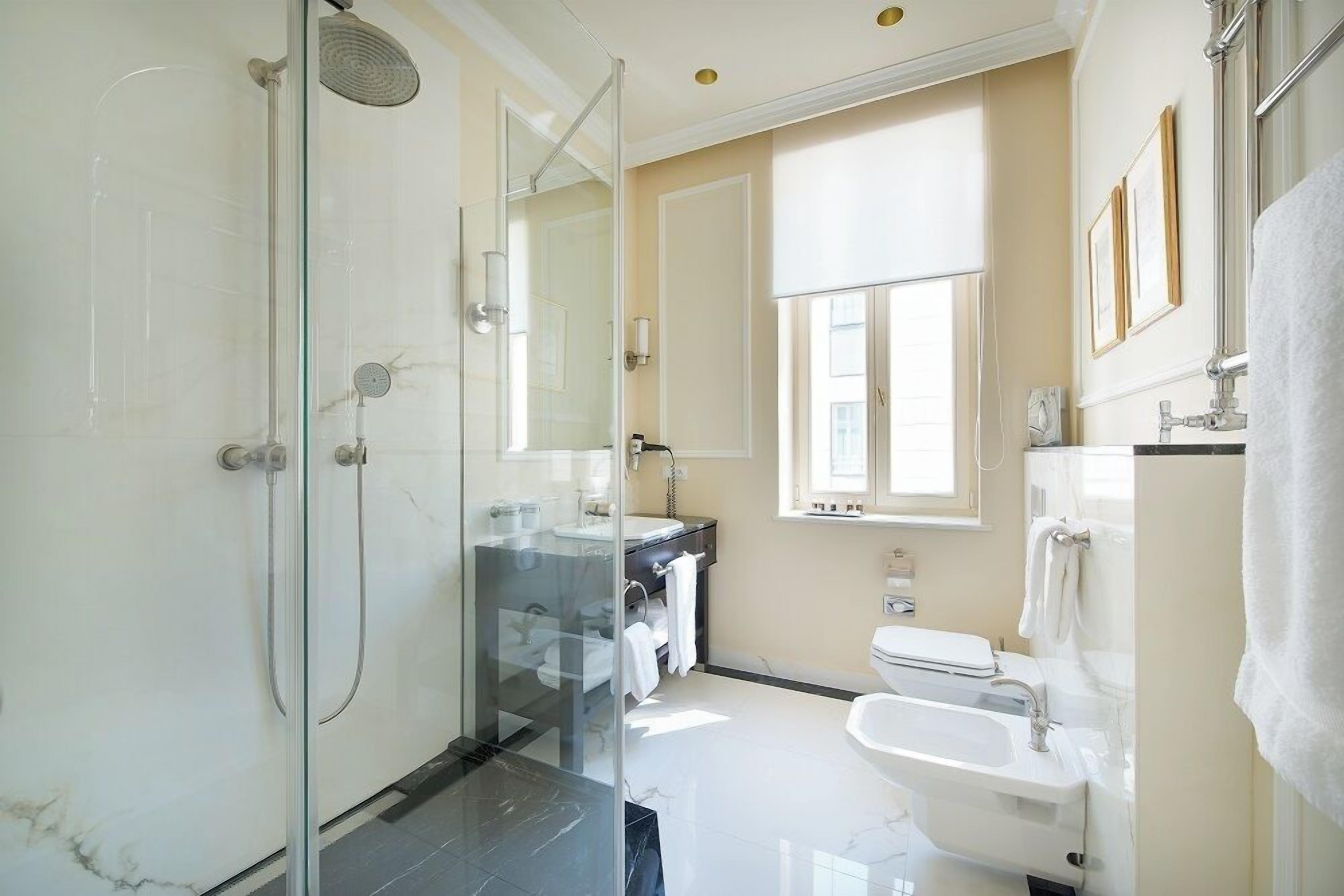 A modern bathroom with a glass-enclosed shower, a vanity with a sink, and a toilet.