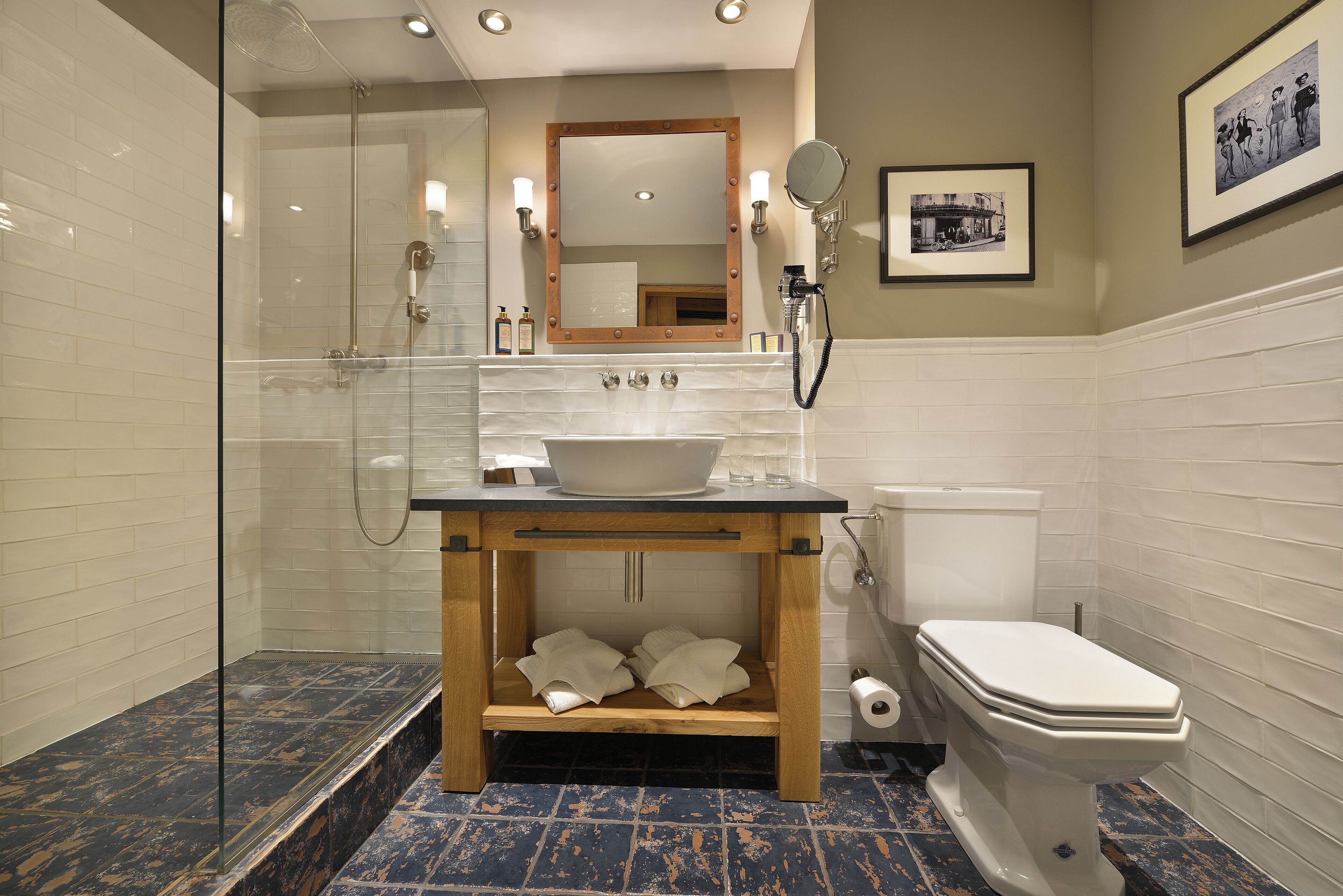 Een moderne badkamer met een douche met glazen wand, een houten wastafelmeubel met een wastafel en een toilet.