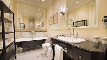 A modern bathroom with a double sink vanity, a freestanding bathtub, and a large mirror.